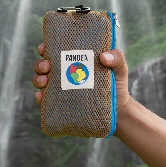 best bamboo towels overall come from pangea, hand holding pangea towel in front of a waterfall
